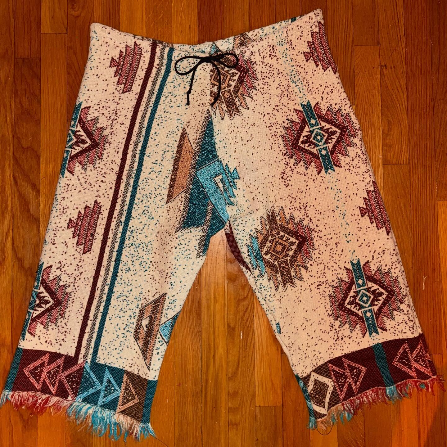 Tapestry pants laid on a wood floor